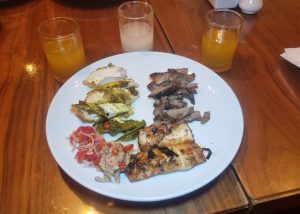 A line of jamu, Temulawak, Beras Kencur and Asam Kunyit with a plate of Marangi roast lamb leg, Betutu chicken and Jimbaran grilled fish with dips of Sambal Matangi and Dabu Dabu